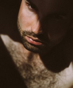 man with facial hair ooking down with shadow on face