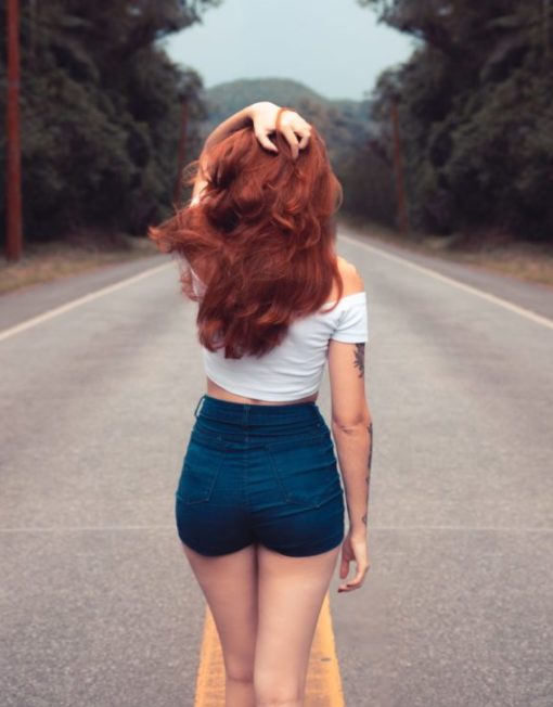 red haired woman with dark denim shorts