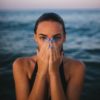 Woman on the beach covering her face