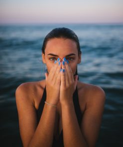 Woman on the beach covering her face