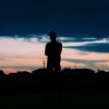 shadowy figure standing looking towards the sky