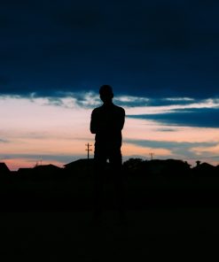 shadowy figure standing looking towards the sky