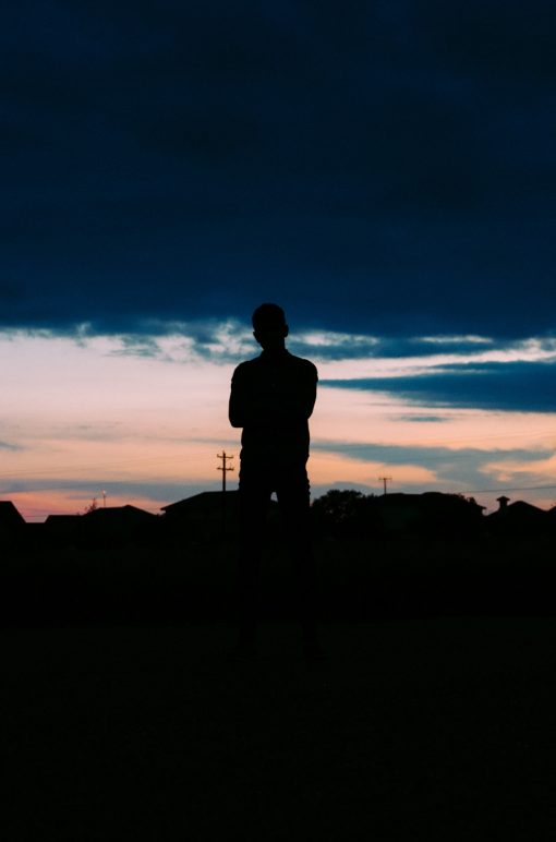 shadowy figure standing looking towards the sky